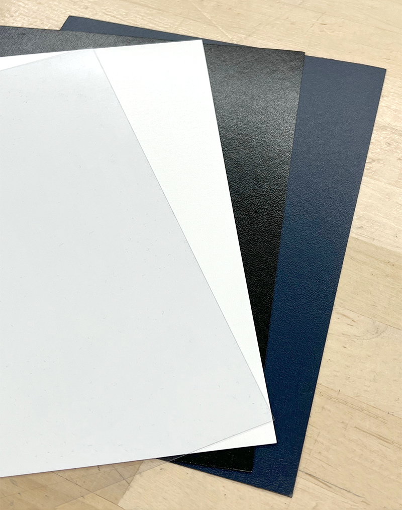 Different color covers laying out on a table top.